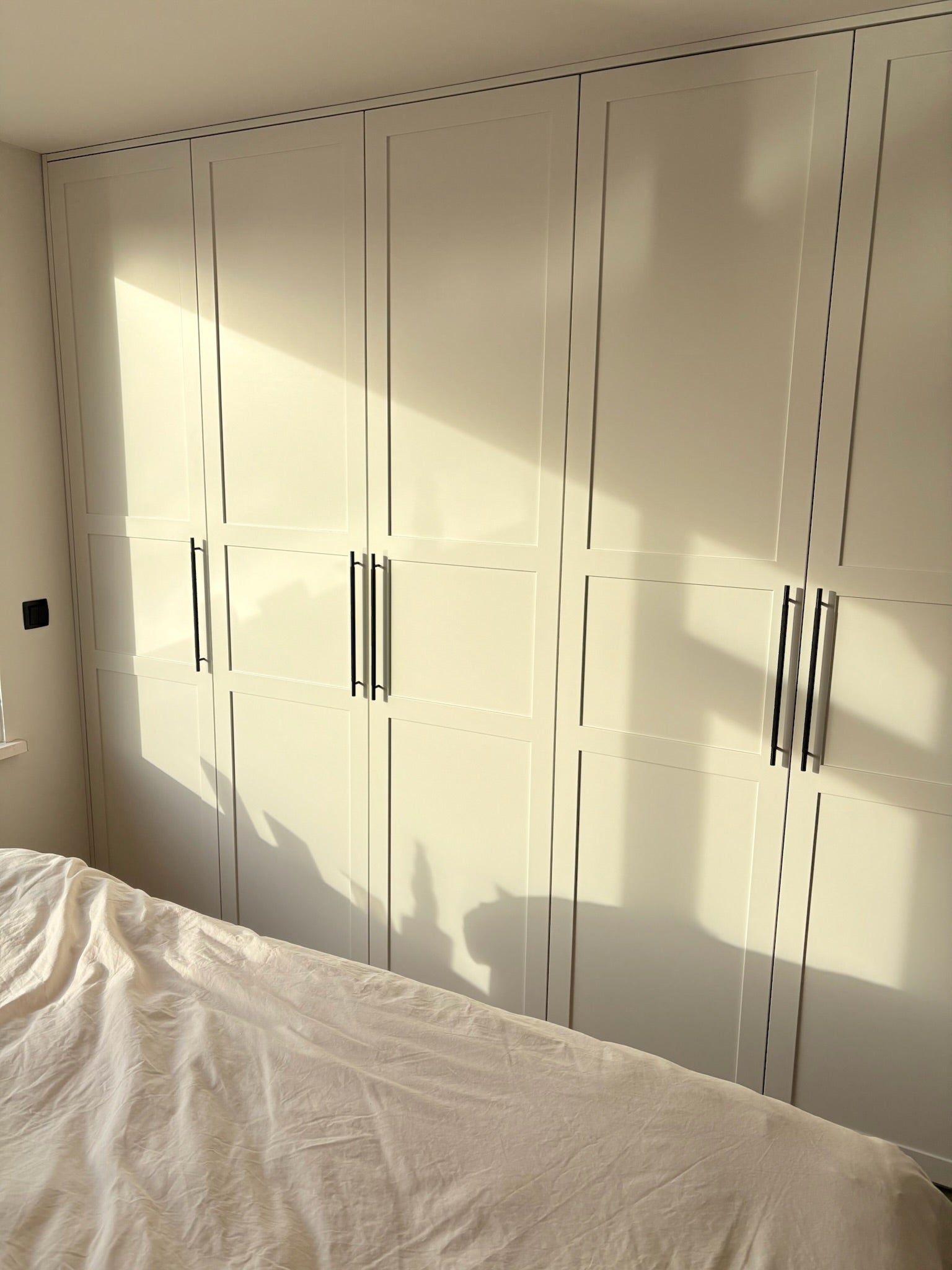 klassieke kledingkast, maatwerk kledingkast, Gespoten kledingkast, kledingkast op maat, kledingkast met paneeldeuren, zwarte grepen, Kledingkast met lades.