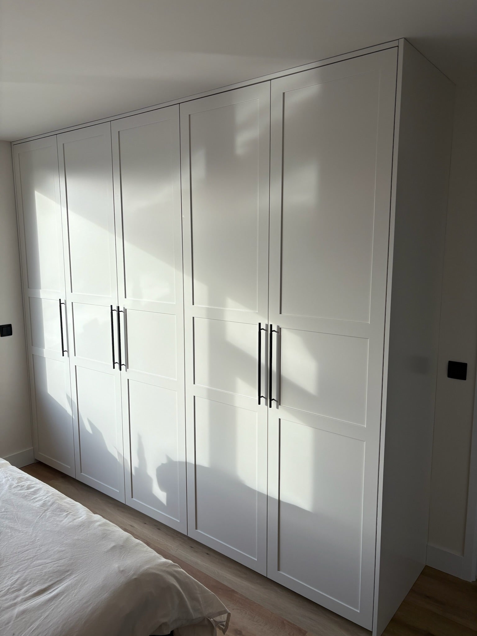 klassieke kledingkast, maatwerk kledingkast, Gespoten kledingkast, kledingkast op maat, kledingkast met paneeldeuren, zwarte grepen, Kledingkast met lades.